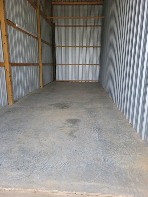 Concrete apron and roll-up door access to enclosed storage unit